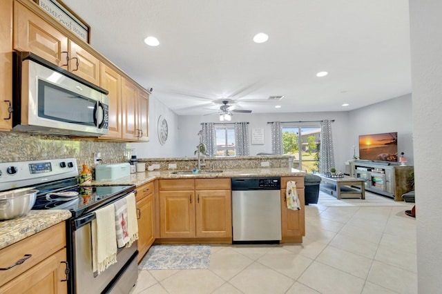 2556 Marshfield Ct, Port Saint Lucie, FL 34953 - kitchen with appliances with stainless steel finishes, a sink, a peninsula, a ceiling fan, and light tile patterned floors