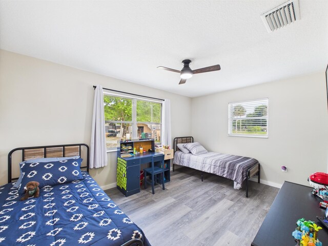 bedroom featuring wood finished floors, baseboards, and a ceiling fan