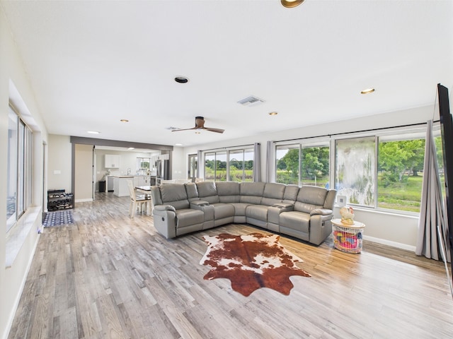 living area featuring light wood-type flooring, baseboards, ceiling fan, and recessed lighting