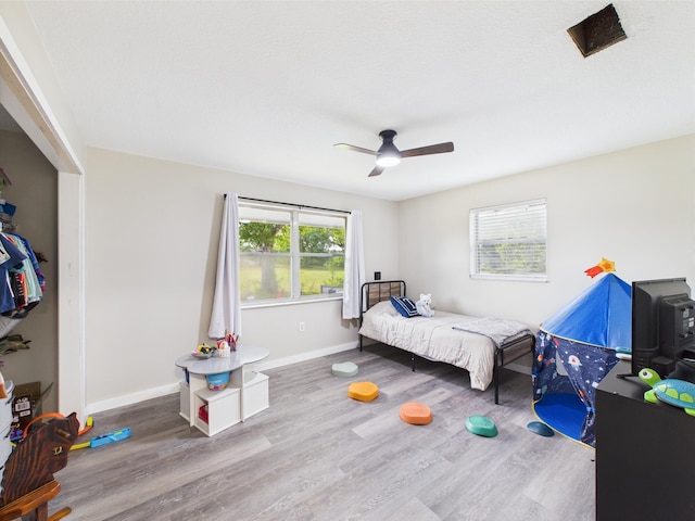 bedroom with wood finished floors, baseboards, and a ceiling fan