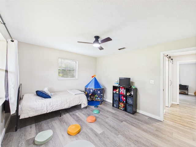 bedroom featuring wood finished floors, baseboards, and a ceiling fan