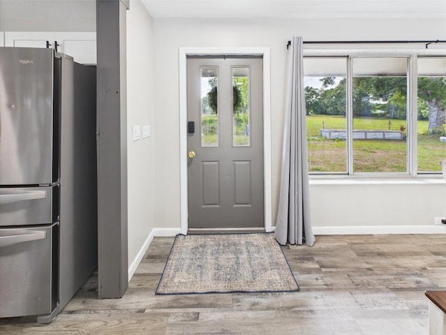 entryway featuring baseboards, light wood-style flooring, and healthy amount of natural light