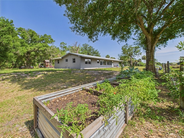 view of green lawn with a garden