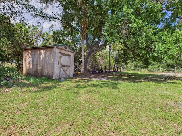 view of grassy yard featuring a storage unit and an outbuilding