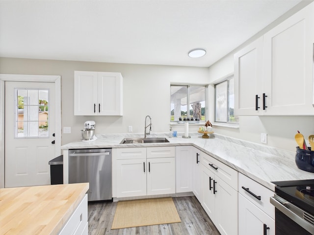 kitchen with dishwasher, a sink, plenty of natural light, and white cabinetry