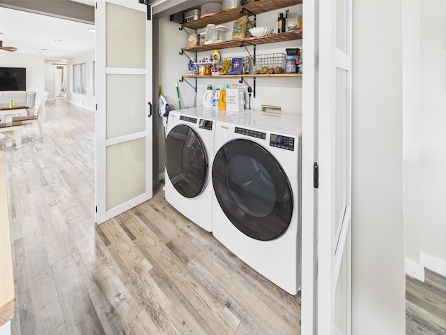 washroom featuring light wood-style flooring, separate washer and dryer, and a ceiling fan