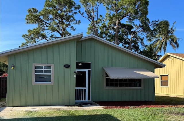 5123 Adams Rd, Delray Beach, FL 33484 - view of front of home with board and batten siding and a front lawn