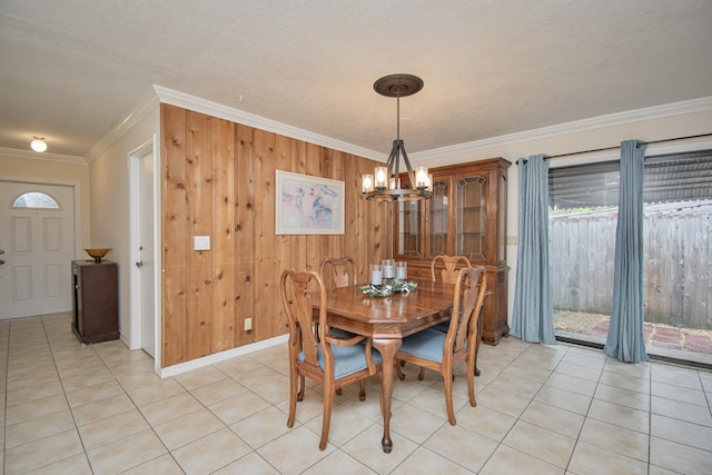 5123 Adams Rd, Delray Beach, FL 33484 - dining area featuring crown molding, a chandelier, wood walls, light tile patterned flooring, and baseboards