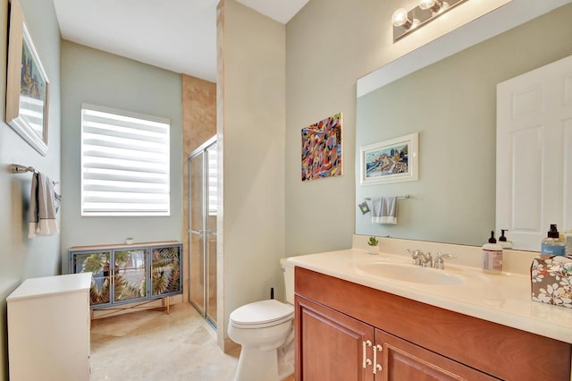 full bathroom featuring a stall shower, toilet, and vanity