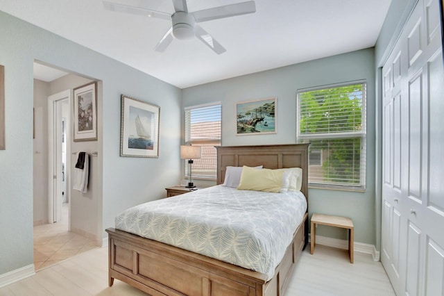 bedroom featuring baseboards, light wood-style floors, and a ceiling fan