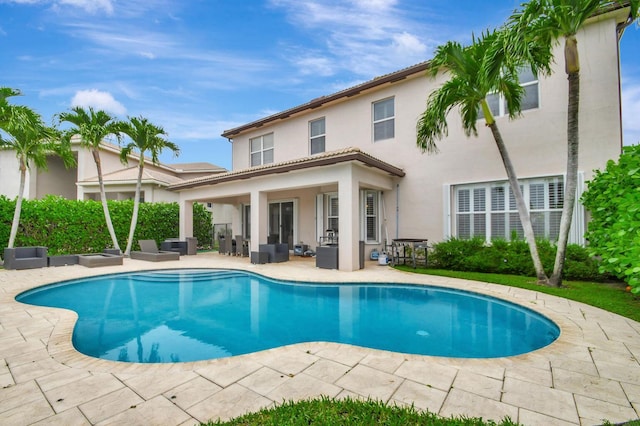 swimming pool with a patio area and an outdoor living space