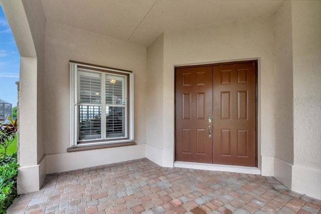 doorway to property featuring stucco siding