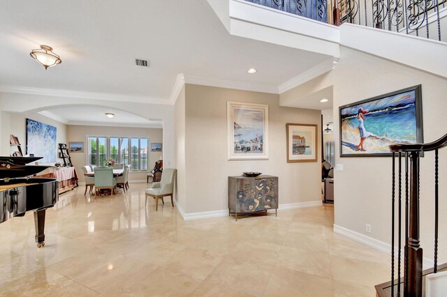 entrance foyer with crown molding, baseboards, arched walkways, and recessed lighting