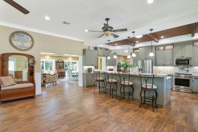 6624 Dillman Rd, West Palm Beach, FL 33413 - kitchen featuring appliances with stainless steel finishes, ceiling fan, gray cabinetry, a kitchen bar, and decorative backsplash