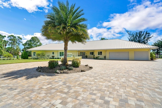 6624 Dillman Rd, West Palm Beach, FL 33413 - view of front of home featuring curved driveway, a garage, metal roof, and stucco siding