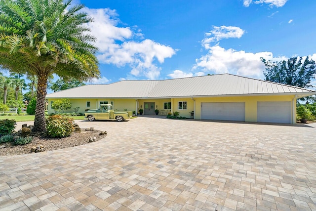 6624 Dillman Rd, West Palm Beach, FL 33413 - view of front of property with a garage, decorative driveway, stucco siding, and metal roof