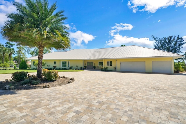 6624 Dillman Rd, West Palm Beach, FL 33413 - view of front of home featuring decorative driveway, an attached garage, stucco siding, and metal roof