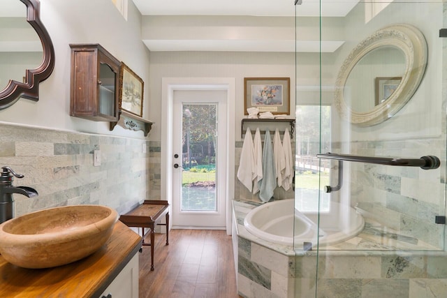 6624 Dillman Rd, West Palm Beach, FL 33413 - full bathroom featuring plenty of natural light, a shower stall, a garden tub, tile walls, and wood finished floors