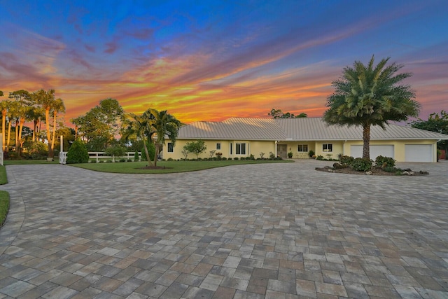 6624 Dillman Rd, West Palm Beach, FL 33413 - view of front of house with curved driveway, an attached garage, a lawn, and stucco siding