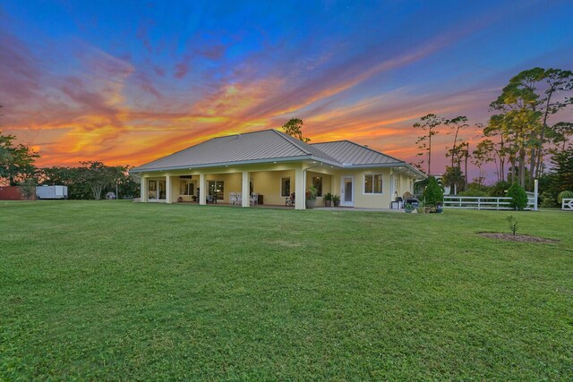 6624 Dillman Rd, West Palm Beach, FL 33413 - back of house at dusk with a patio area, metal roof, a standing seam roof, and stucco siding