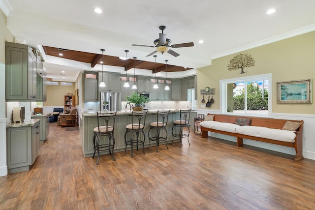 6624 Dillman Rd, West Palm Beach, FL 33413 - kitchen featuring appliances with stainless steel finishes, ceiling fan, wood finished floors, a breakfast bar, and ornamental molding