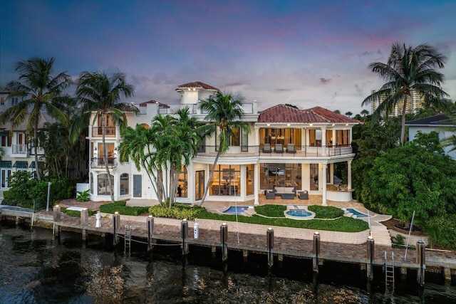 155 SE Spanish Trl, Boca Raton, FL 33432 - rear view of property with a balcony, outdoor lounge area, a patio, a water view, and stucco siding
