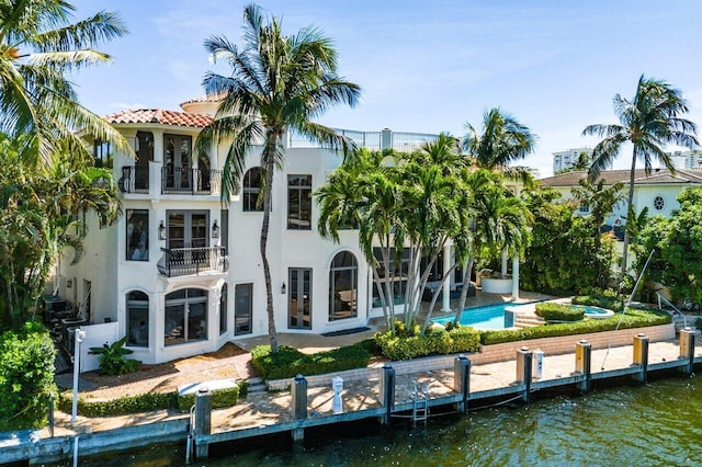 155 SE Spanish Trl, Boca Raton, FL 33432 - back of property featuring a balcony, stucco siding, a tiled roof, and a water view