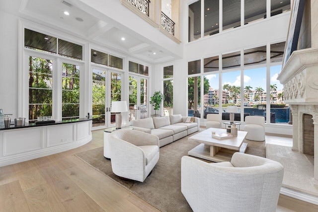 155 SE Spanish Trl, Boca Raton, FL 33432 - living area featuring a towering ceiling, light wood-style floors, beamed ceiling, a premium fireplace, and recessed lighting