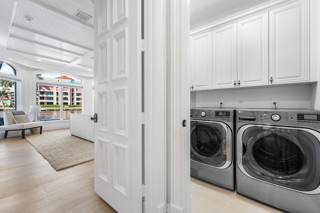 155 SE Spanish Trl, Boca Raton, FL 33432 - laundry room featuring washing machine and dryer, cabinet space, and light wood-style floors