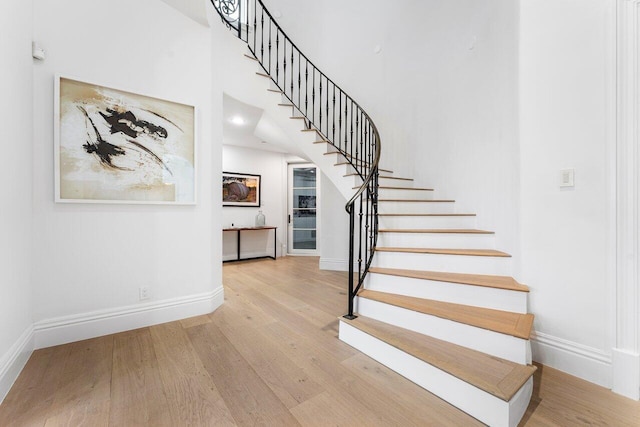 155 SE Spanish Trl, Boca Raton, FL 33432 - stairway featuring wood finished floors, baseboards, and a towering ceiling