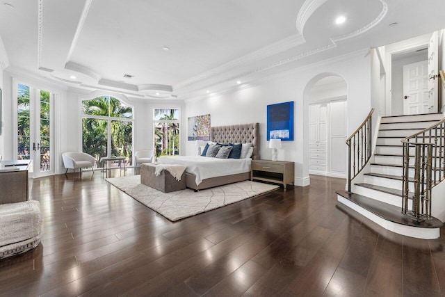 155 SE Spanish Trl, Boca Raton, FL 33432 - bedroom featuring a tray ceiling, ornamental molding, wood finished floors, arched walkways, and baseboards