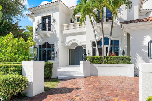 155 SE Spanish Trl, Boca Raton, FL 33432 - view of front of home featuring stucco siding, a tile roof, and a balcony
