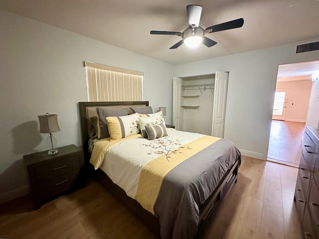 bedroom featuring wood finished floors, a closet, ceiling fan, and baseboards