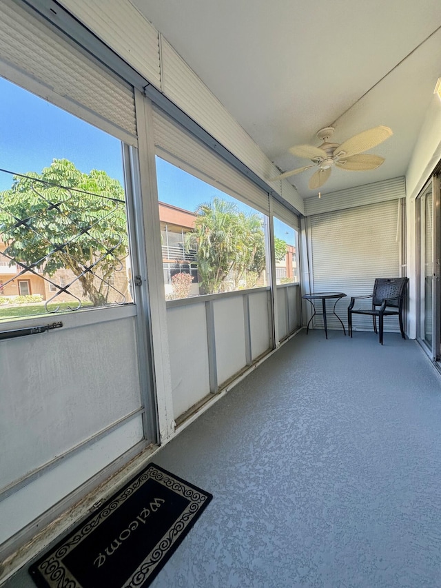 unfurnished sunroom with a ceiling fan