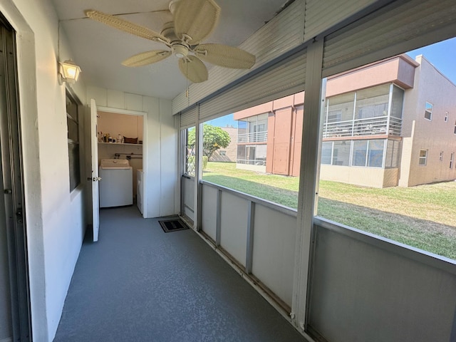 unfurnished sunroom featuring washer / clothes dryer and a ceiling fan