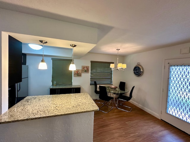 kitchen with baseboards, dark wood-style flooring, a chandelier, and decorative light fixtures