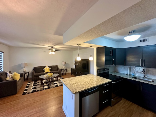 kitchen with stainless steel appliances, a sink, open floor plan, dark wood-type flooring, and a ceiling fan