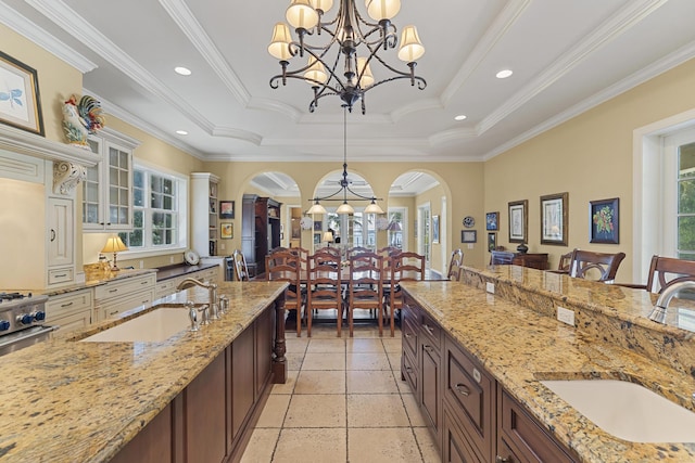 11 Wendy Ln, Stuart, FL 34994 - kitchen with a sink, a raised ceiling, glass insert cabinets, a chandelier, and crown molding