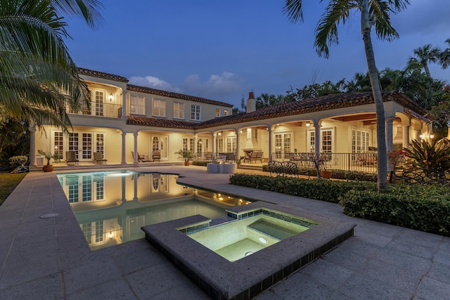 11 Wendy Ln, Stuart, FL 34994 - back of house with french doors, a tiled roof, a patio area, stucco siding, and a pool with connected hot tub