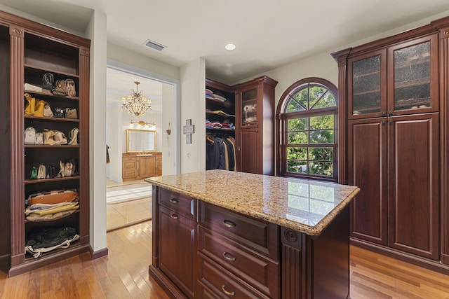 11 Wendy Ln, Stuart, FL 34994 - walk in closet with light wood-style flooring and a chandelier