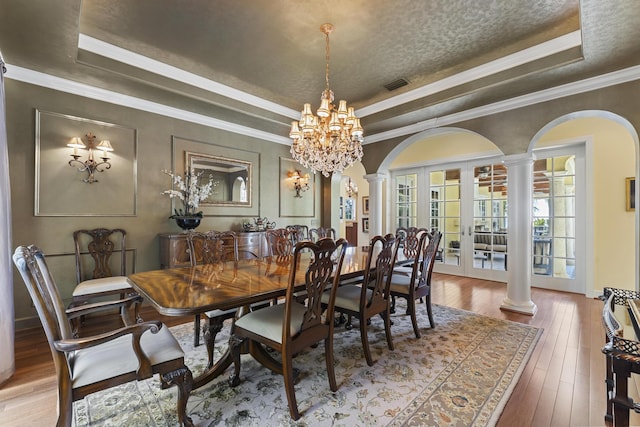 11 Wendy Ln, Stuart, FL 34994 - dining room with a raised ceiling, ornate columns, arched walkways, ornamental molding, and a textured ceiling