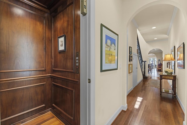 11 Wendy Ln, Stuart, FL 34994 - hall featuring elevator, arched walkways, dark wood finished floors, baseboards, and crown molding