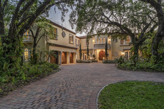 11 Wendy Ln, Stuart, FL 34994 - mediterranean / spanish house with decorative driveway, a balcony, stucco siding, and an attached garage