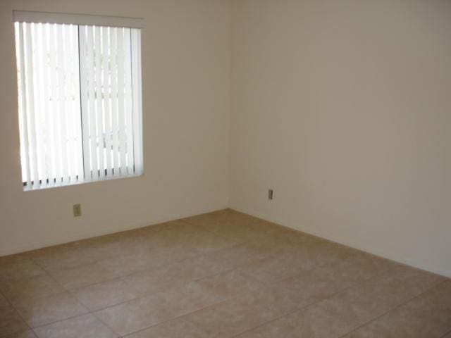 unfurnished room with plenty of natural light and light tile patterned floors
