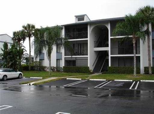 view of property featuring uncovered parking and stairway