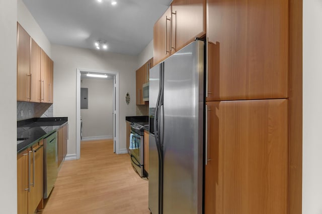 101 SE 20th Ave Unit 501, Deerfield Beach, FL 33441 - kitchen featuring stainless steel appliances, dark countertops, light wood-type flooring, tasteful backsplash, and baseboards