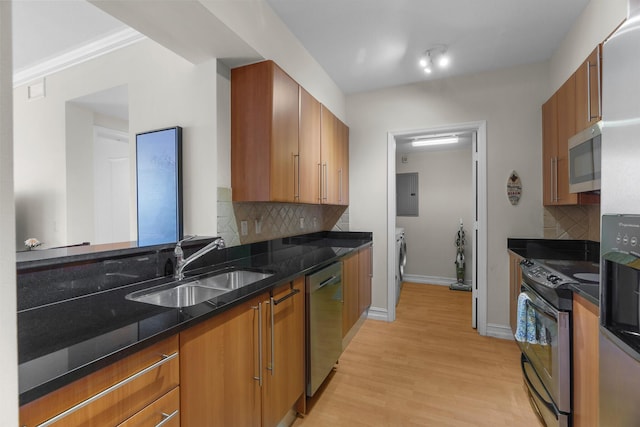 101 SE 20th Ave Unit 501, Deerfield Beach, FL 33441 - kitchen with appliances with stainless steel finishes, a sink, separate washer and dryer, light wood-style floors, and brown cabinets