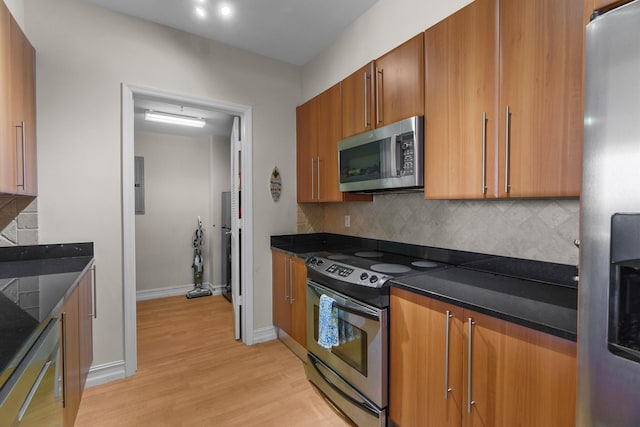 101 SE 20th Ave Unit 501, Deerfield Beach, FL 33441 - kitchen with appliances with stainless steel finishes, dark countertops, light wood-style flooring, and brown cabinets