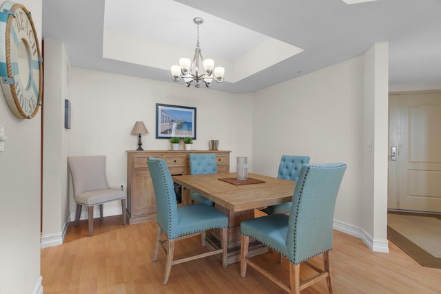 101 SE 20th Ave Unit 501, Deerfield Beach, FL 33441 - dining space featuring light wood-style floors, a chandelier, baseboards, and a raised ceiling