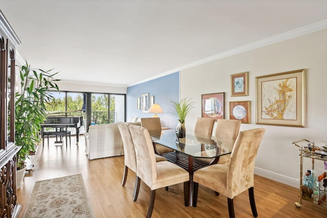 dining room featuring ornamental molding, wood finished floors, and baseboards